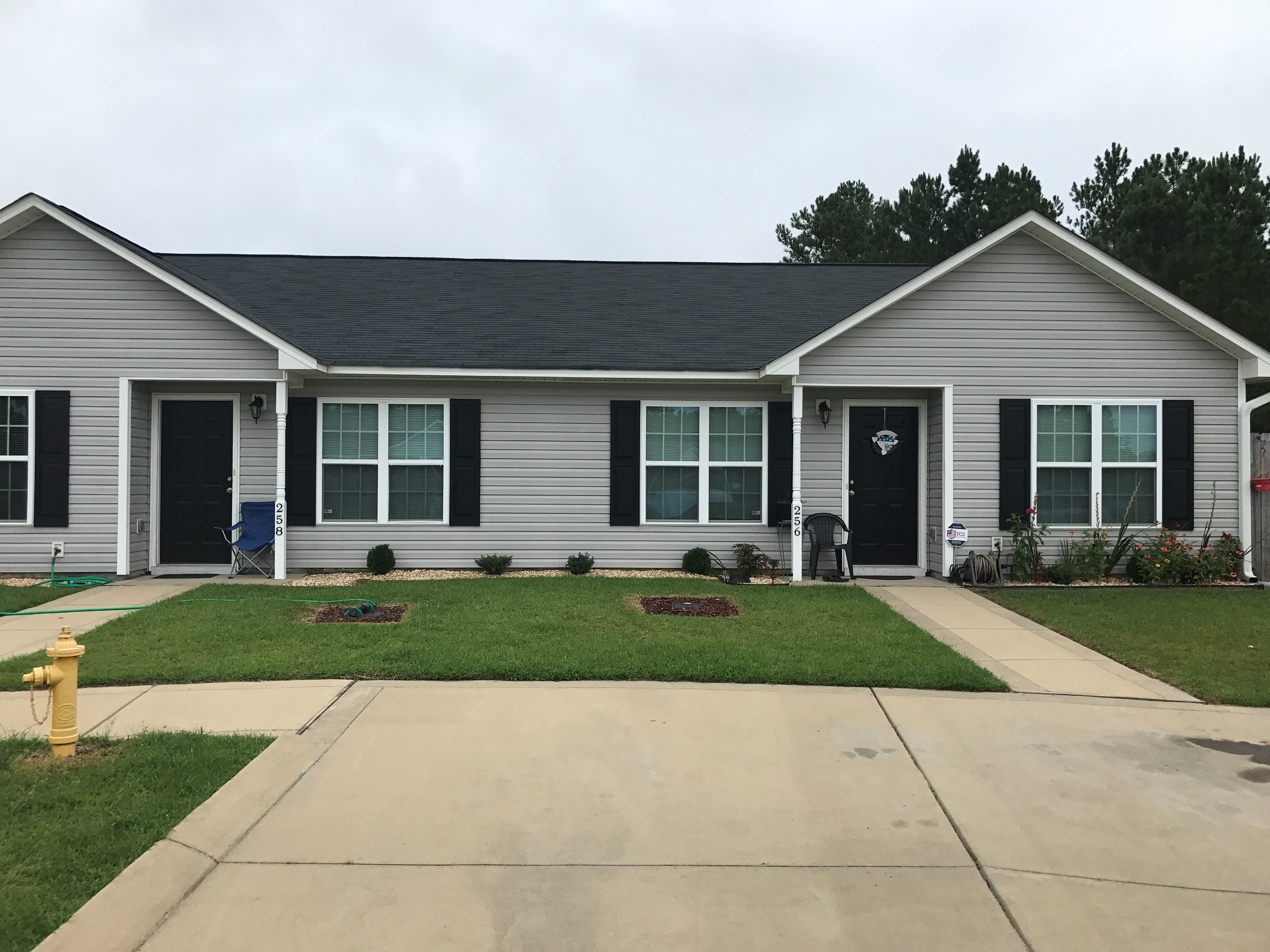 a white house with black shutters and a driveway